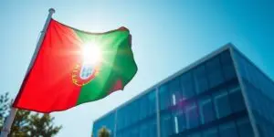 A Portuguese flag waving in front of a modern office building.